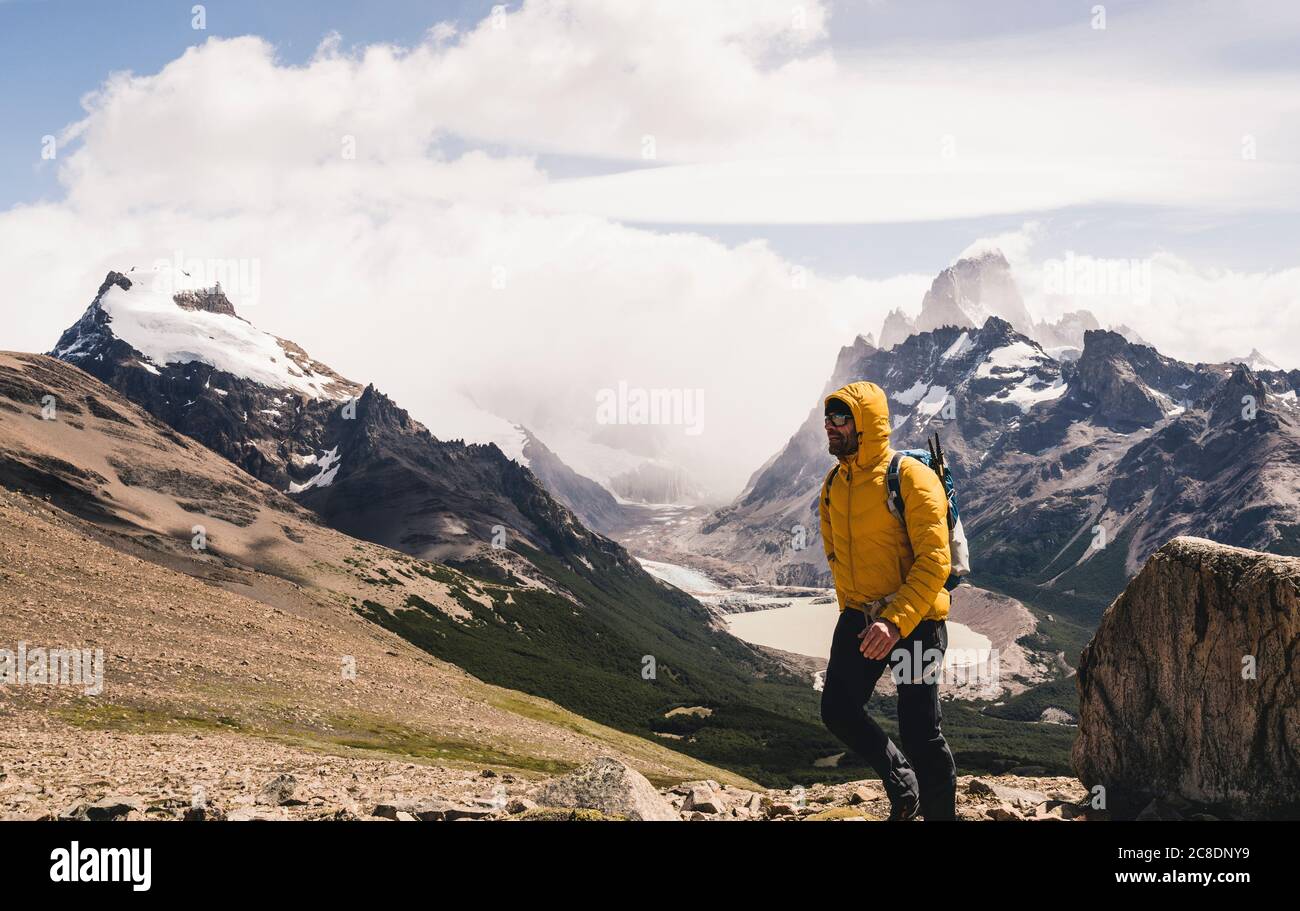 Man walking on mountain against cloudy sky, Patagonia, Argentina Stock Photo