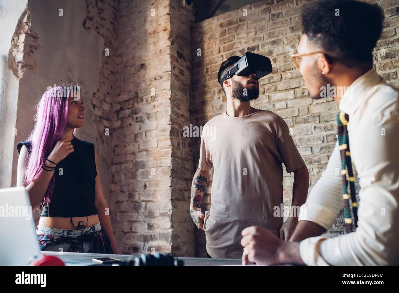 Creative team using Vr goggles in loft office Stock Photo