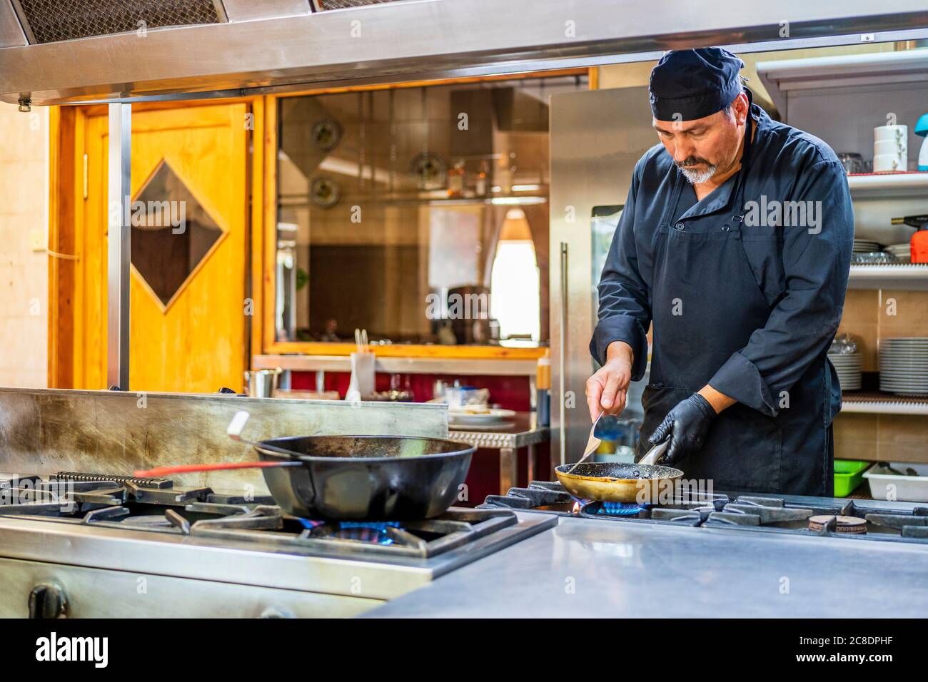 Chef with pan in traditional Spanish restaurant kitchen Stock Photo Alamy