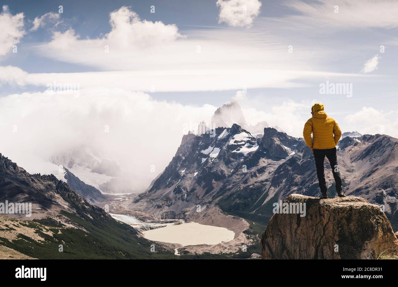Man looking at snowcapped mountain against cloudy sky, Patagonia, Argentina Stock Photo