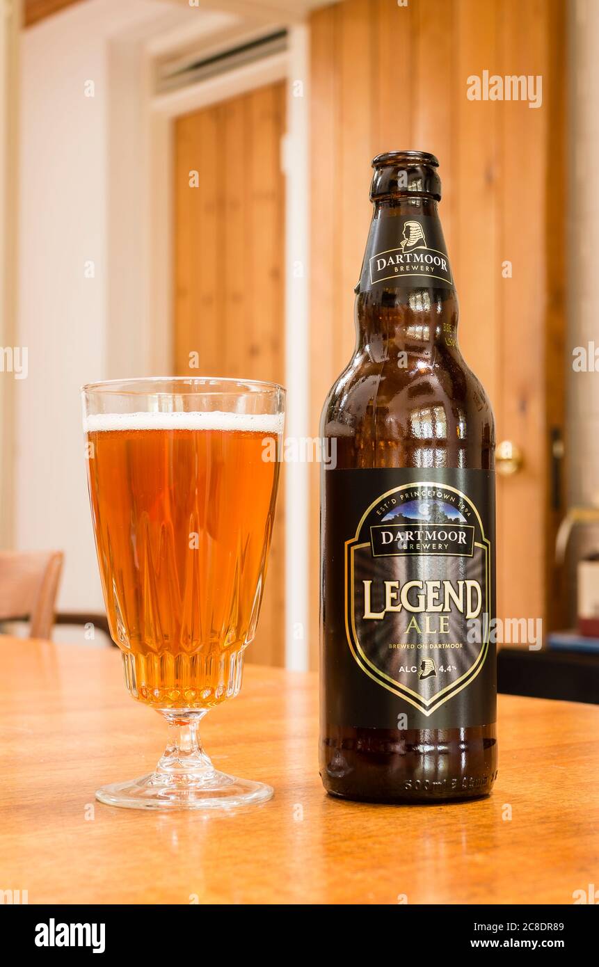A glass containing Dartmooor Legend ale served from a brown glass bottle in UK Stock Photo
