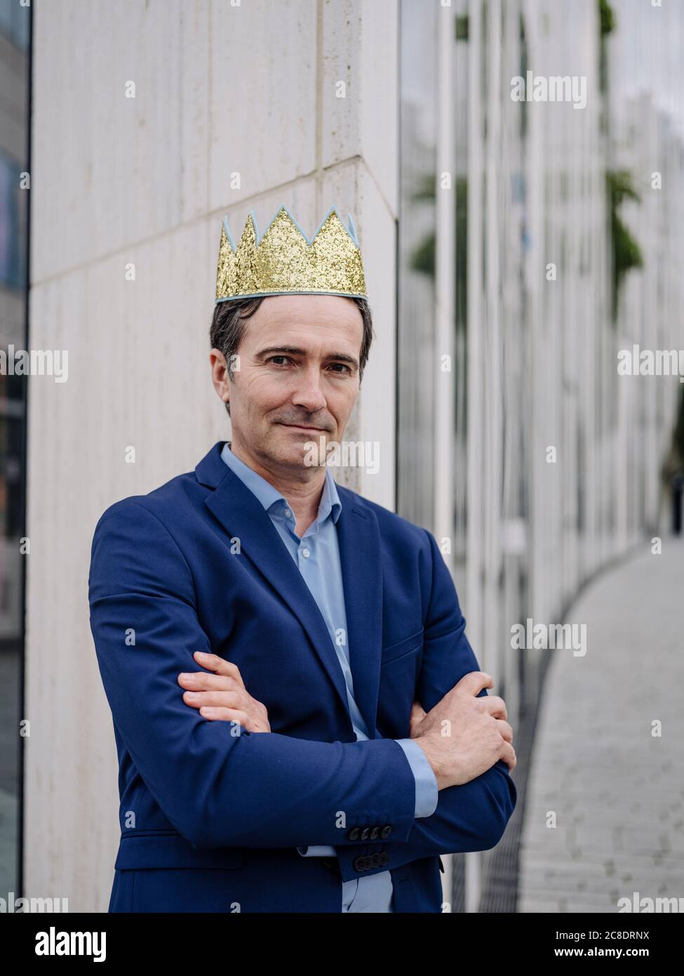 Portrait of a confident mature businessman wearing a toy crown in the city Stock Photo