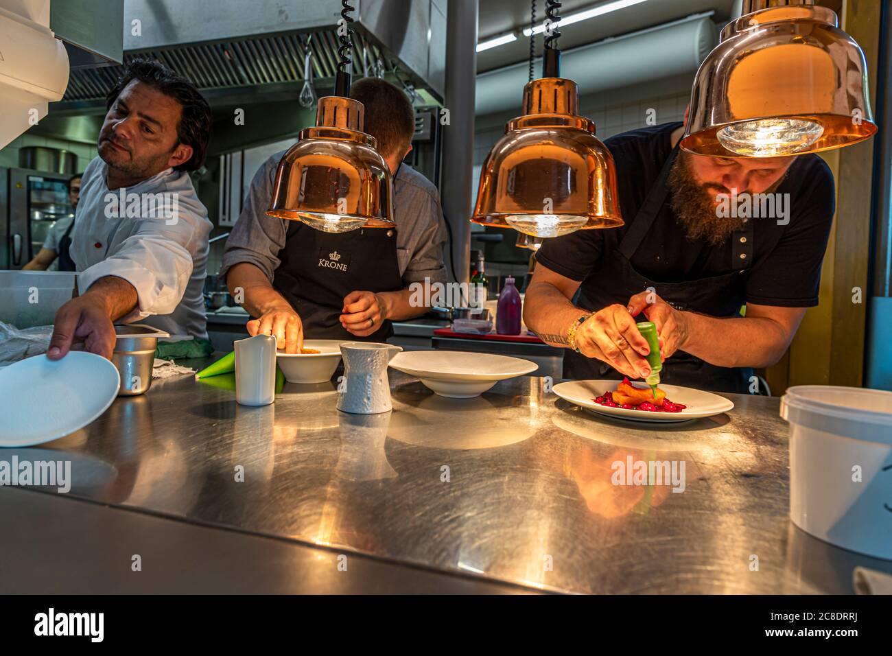 Outside catering with artistically designed partition walls and waiters with protective masks in Hotel Krone in Weil am Rhein, Germany. Peter Prüfer with team at the pass of the summer kitchen, which serves the guests on the terrace Stock Photo