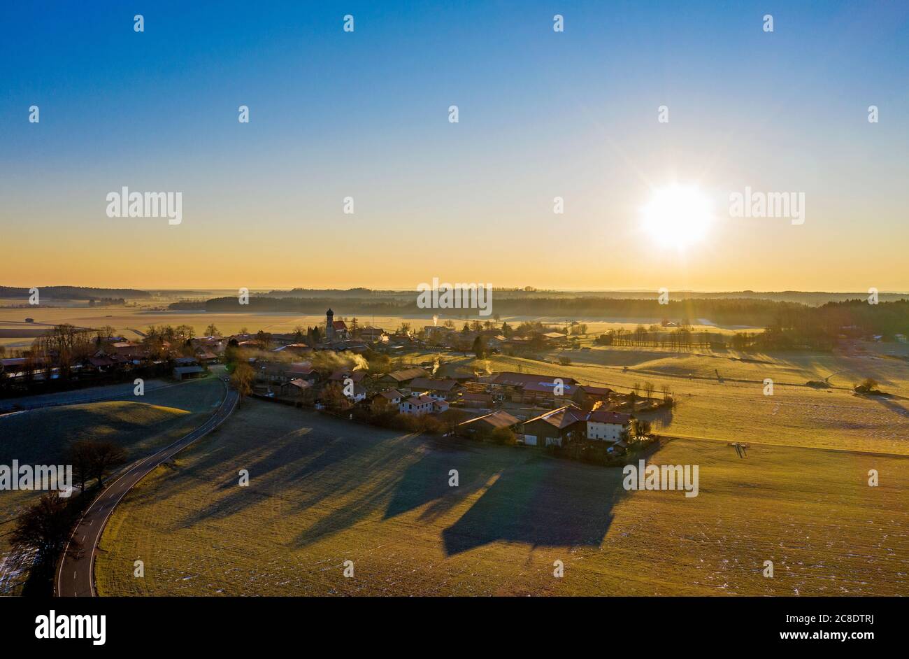 Germany, Bavaria, Dietramszell, Drone view of countryside village at sunrise Stock Photo