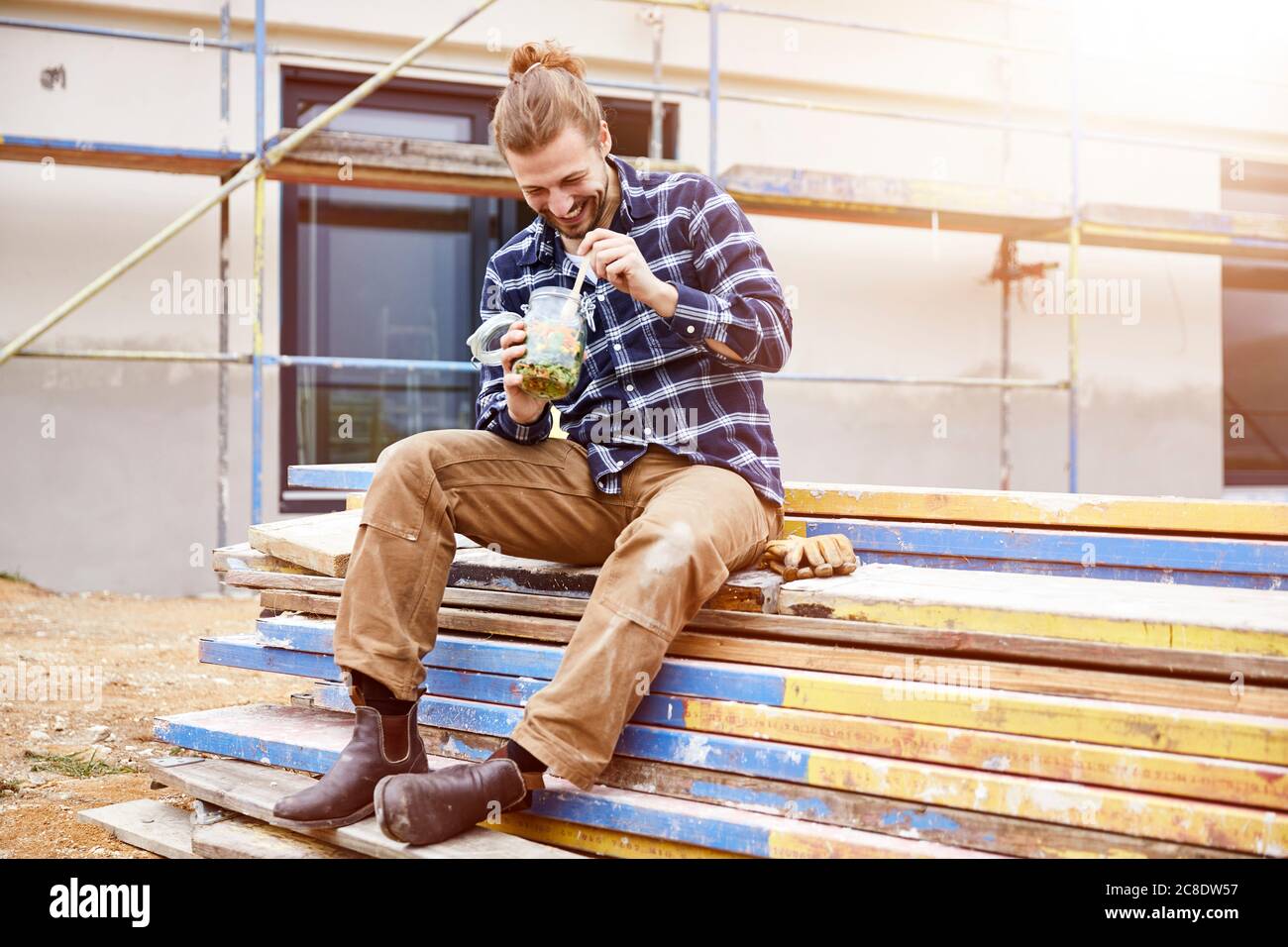 Happy worker having lunch break on a construction site Stock Photo