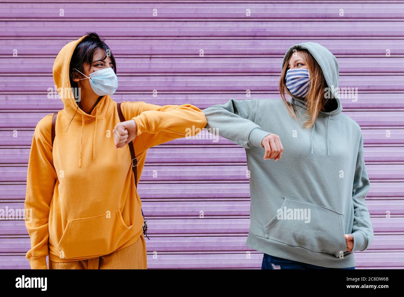 Young woman wearing masks greeting with elbow Stock Photo