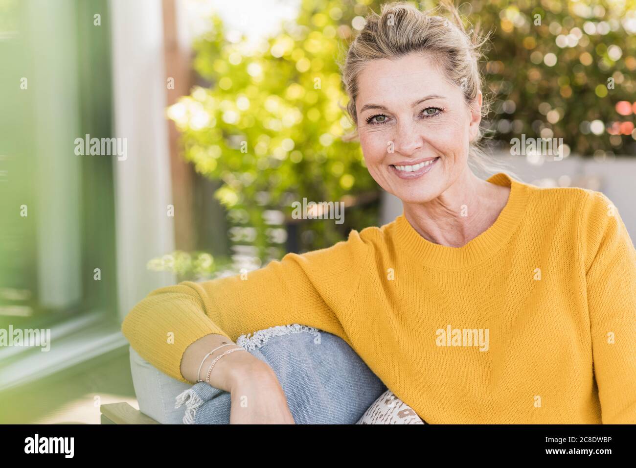 Portrait of smiling mature woman sitting on terrace Stock Photo - Alamy