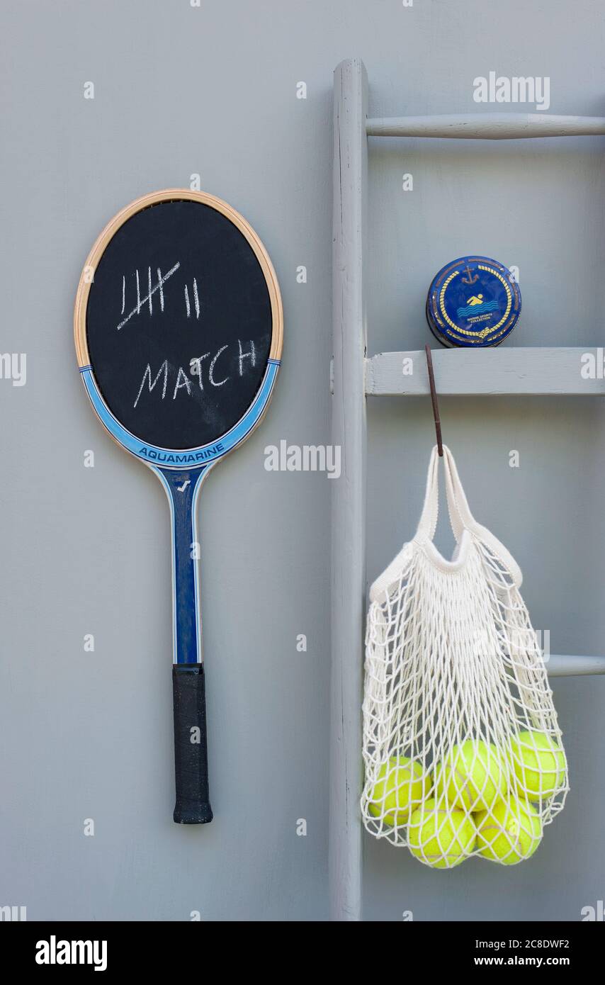 Blackboard made from tennis racket, ladder, small box and mesh bag with tennis balls Stock Photo