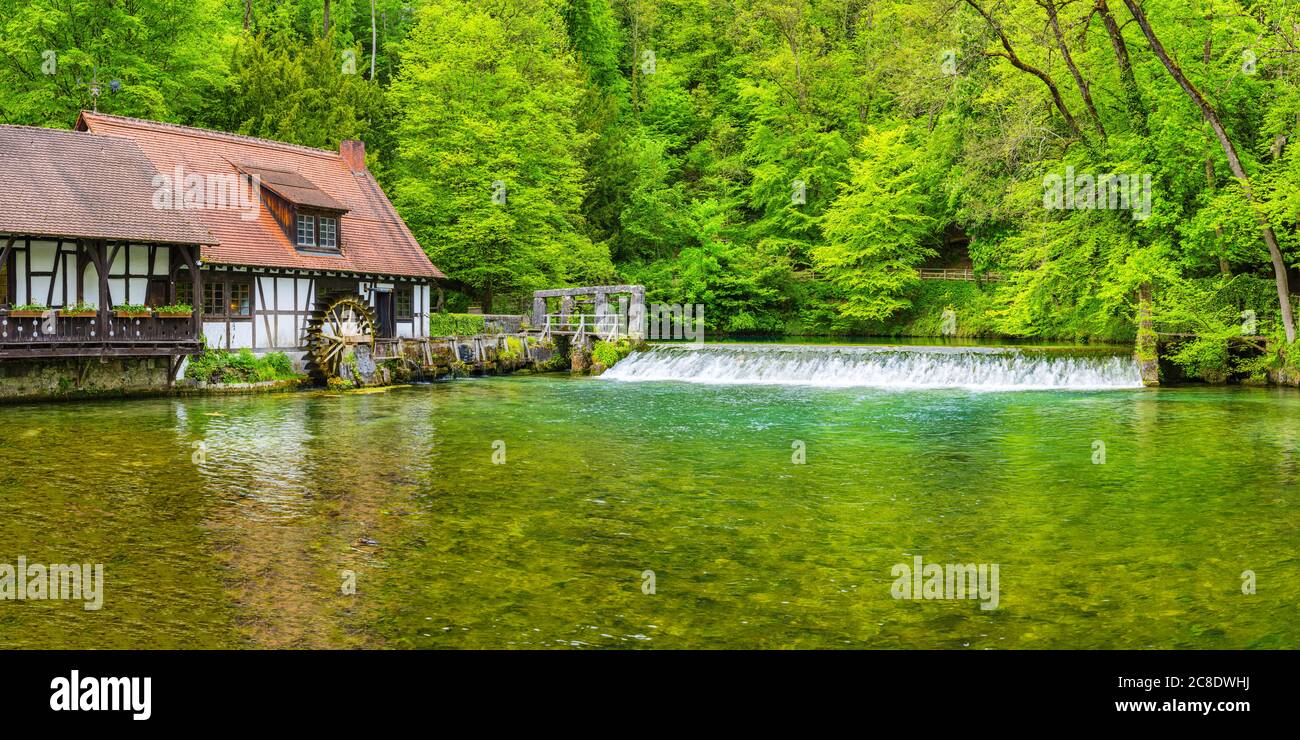 Germany, Baden-Wurttemberg, Blaubeuren, Rustic house on forest riverbank in spring Stock Photo