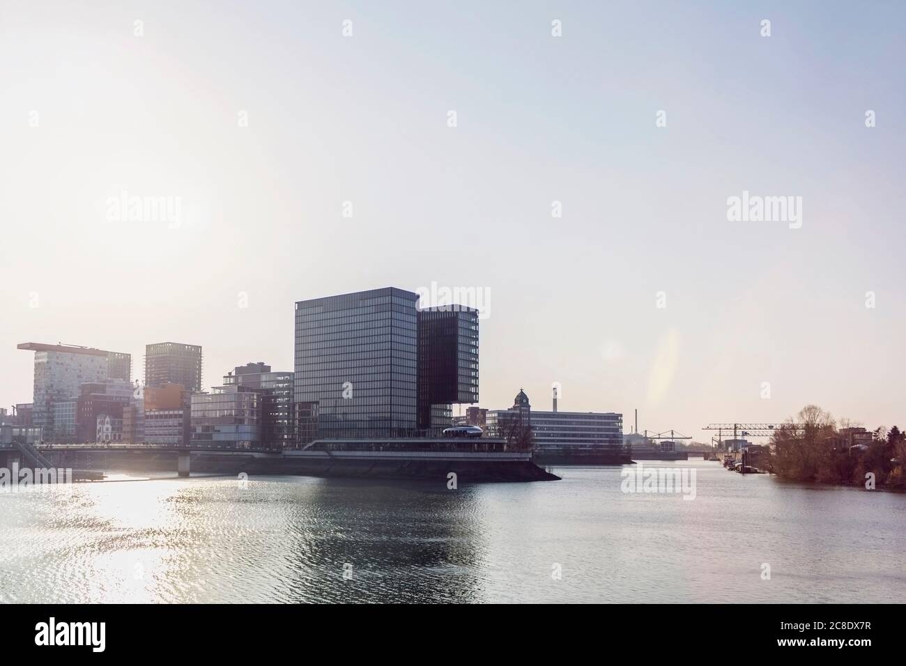 Germany, North Rhine-Westfalia, Dusseldorf, Sun shining over Media Harbor with Stadttor in background Stock Photo