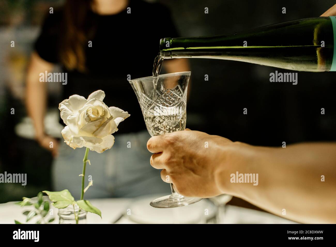 Arm of woman pouring wine during dinner Stock Photo Alamy