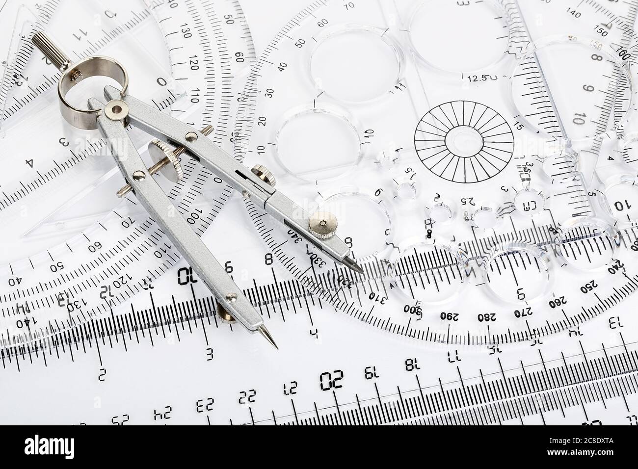pair of compasses on transparent rulers and protractors Stock Photo Alamy
