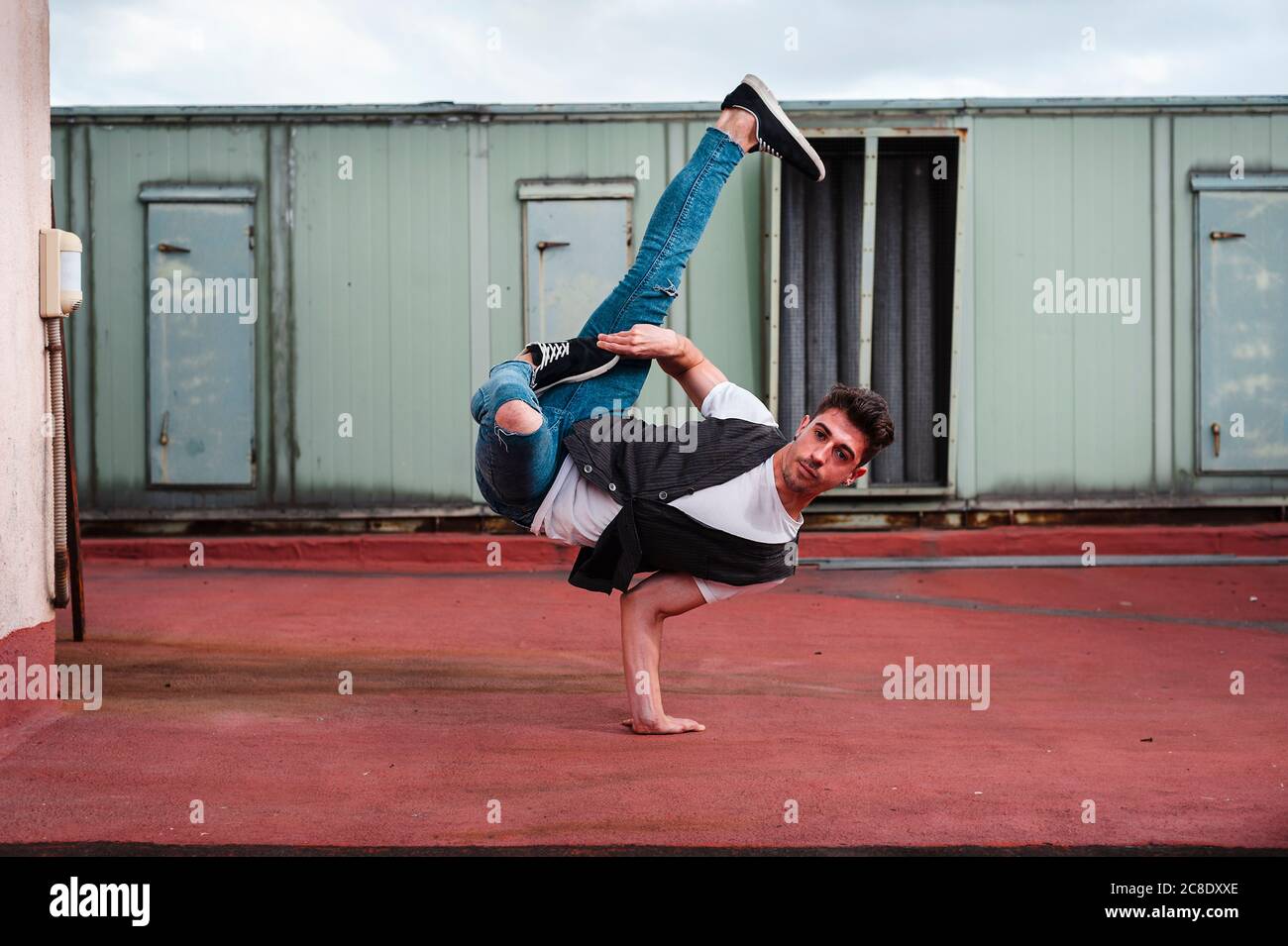 Young man breakdancing on abandoned building terrace Stock Photo