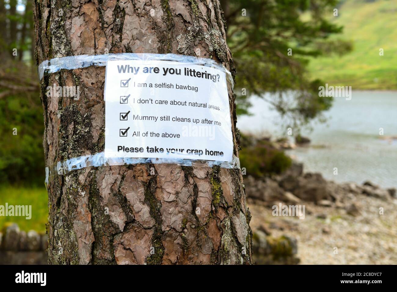 Litter problems constant problem in Loch Lomond and the Trossachs National Park during coronavirus pandemic - sign by Loch Chon asking why - Scotland Stock Photo