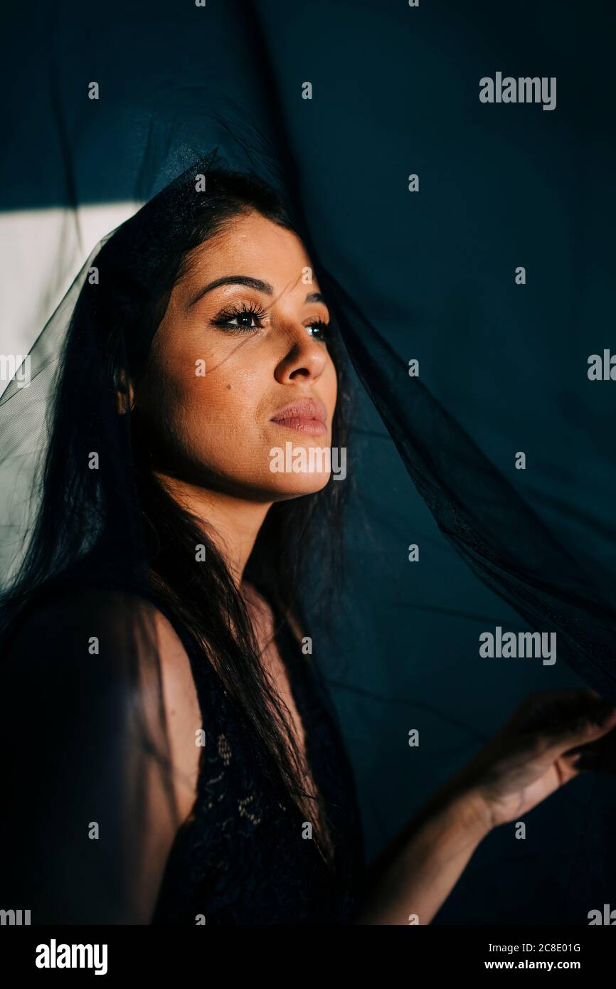 Close-up of thoughtful young woman wearing black veil at home Stock Photo