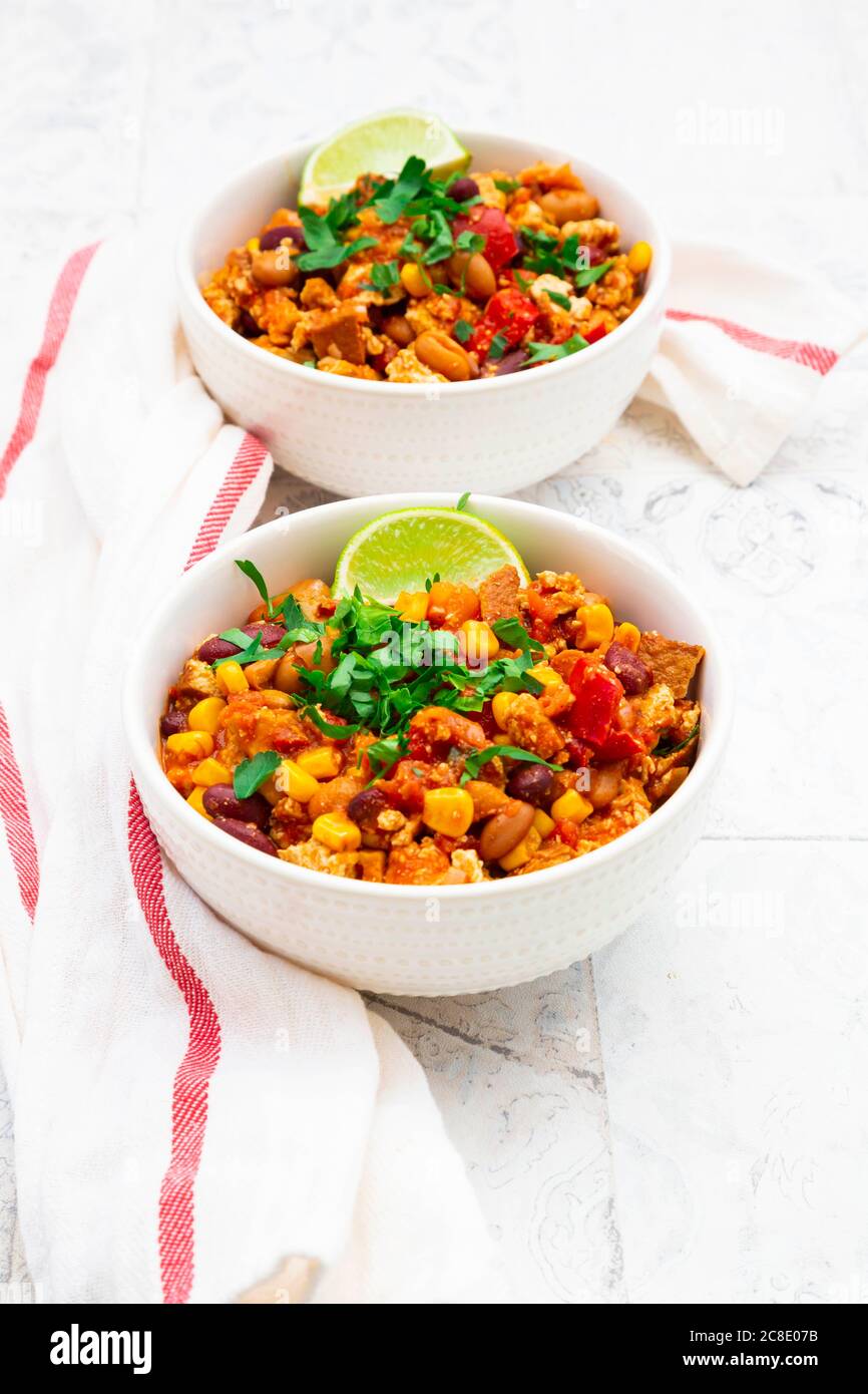 Two bowls of vegetarian chili with tofu, corn, kidney and pinto beans