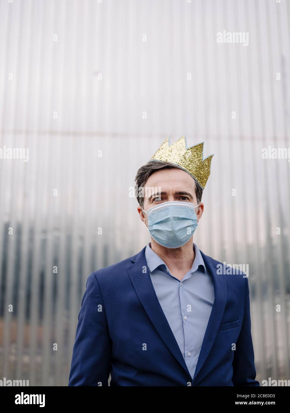 Portrait of a mature businessman wearing a toy crown and protective face mask Stock Photo