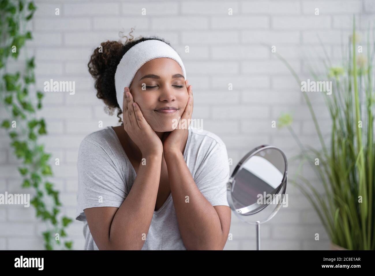 Woman with eyes closed applying cleansing foam on face at home Stock Photo