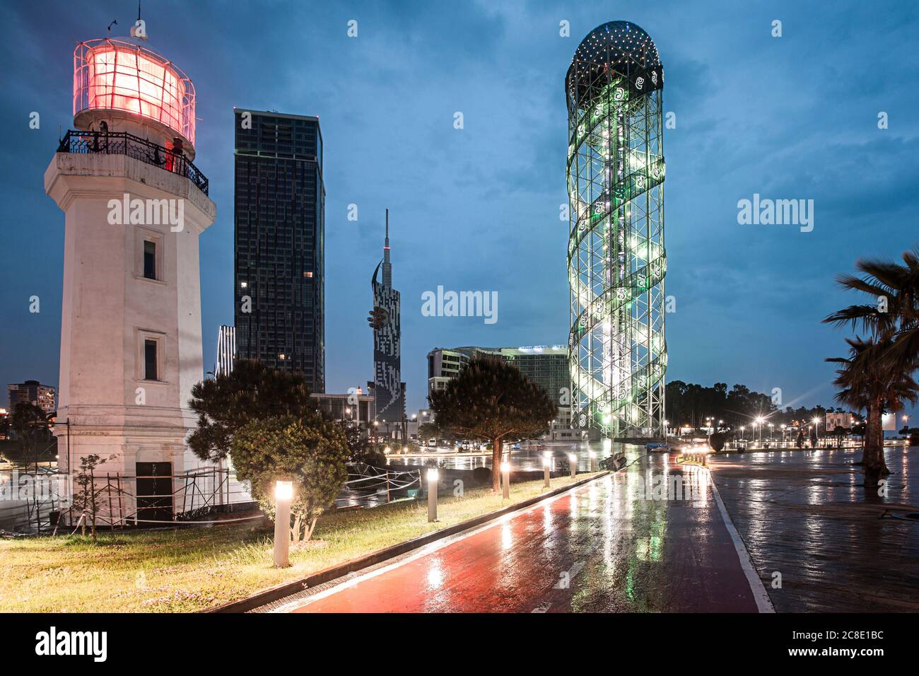 Georgia, Adjara, Batumi, Road in front of illuminated Batumi Lighthouse and Alphabetic Tower at dusk Stock Photo