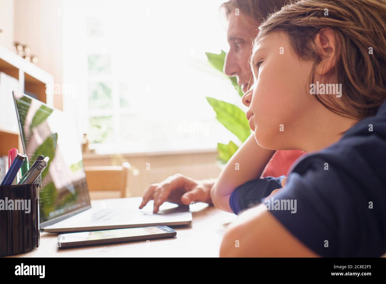 Father and son using laptop while doing studying at home Stock Photo