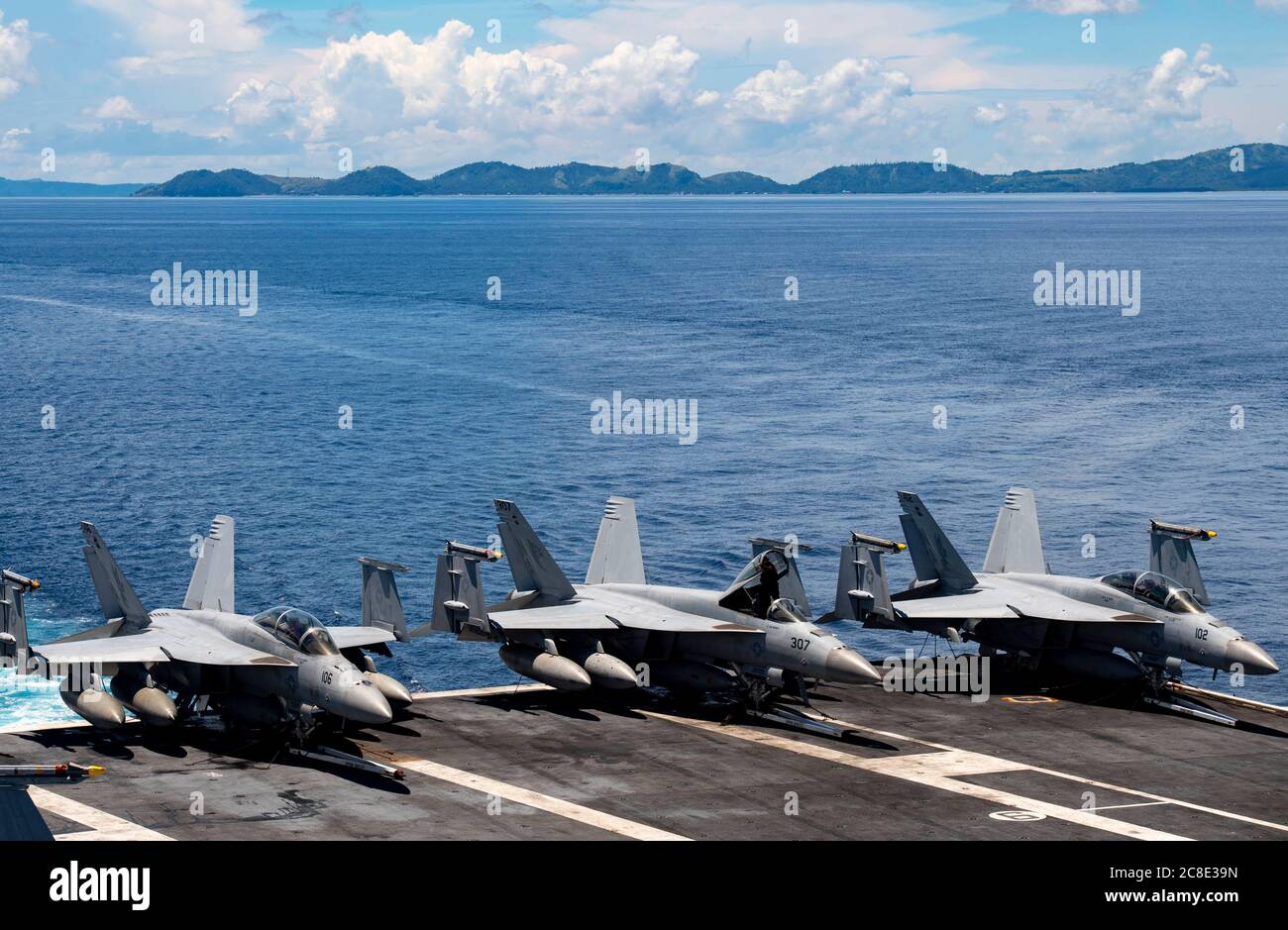 U.S. Navy F/A-18E Super Hornet fighter aircraft, lined up on the flight deck of the Nimitz-class nuclear aircraft carrier USS Nimitz underway transiting the Surigao Strait July 14, 2020 in the Philippine Sea. Stock Photo