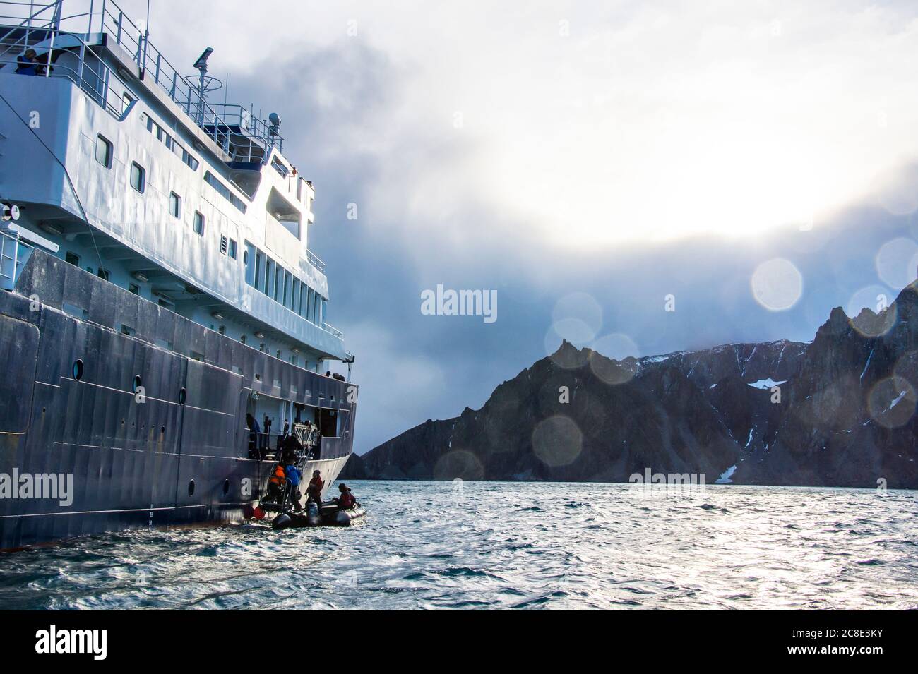 Tourists boarding cruise ship from inflatable raft near shore of Elephant Island Stock Photo