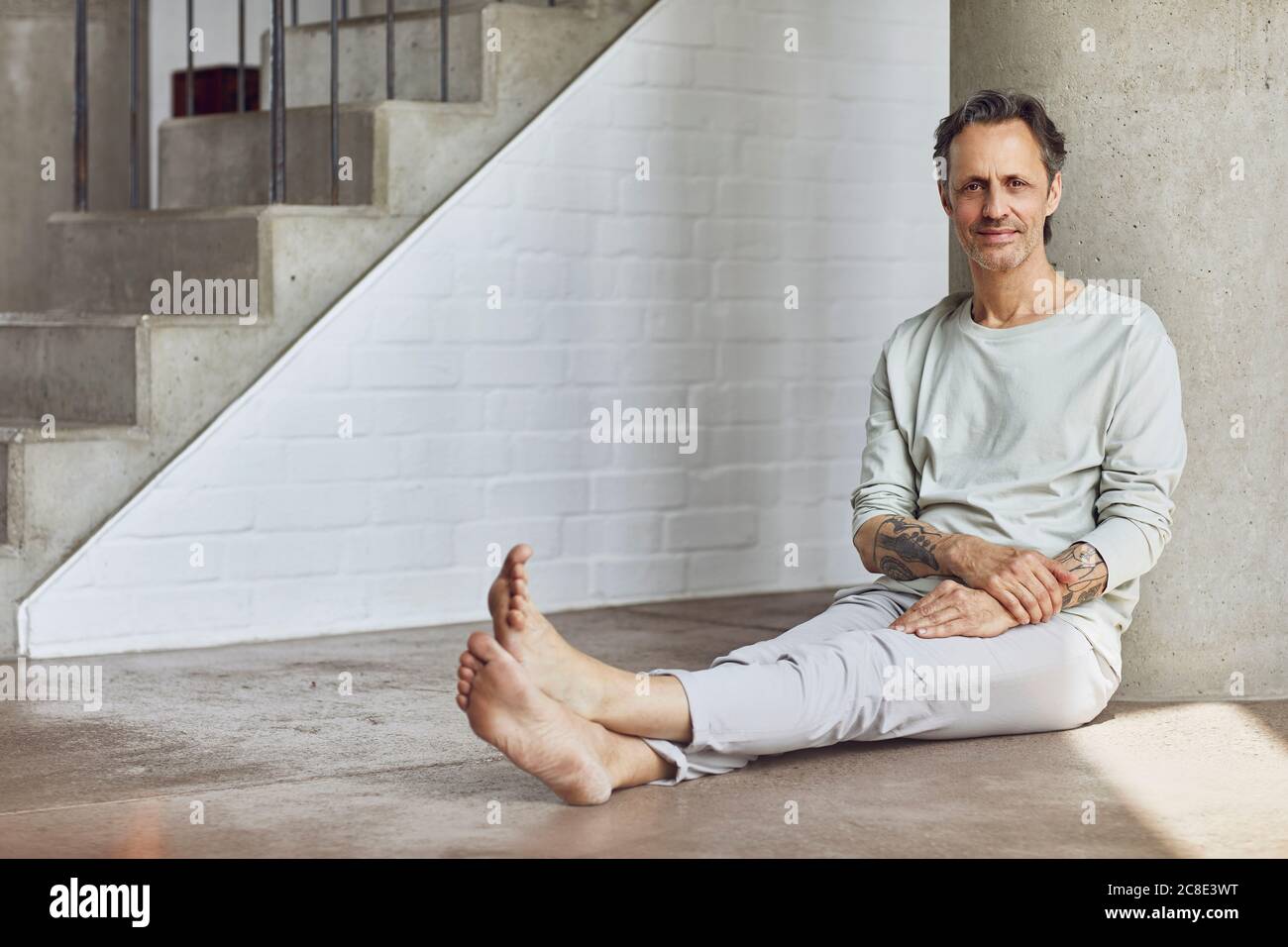 Senior man sitting on the floor in a loft flat Stock Photo - Alamy