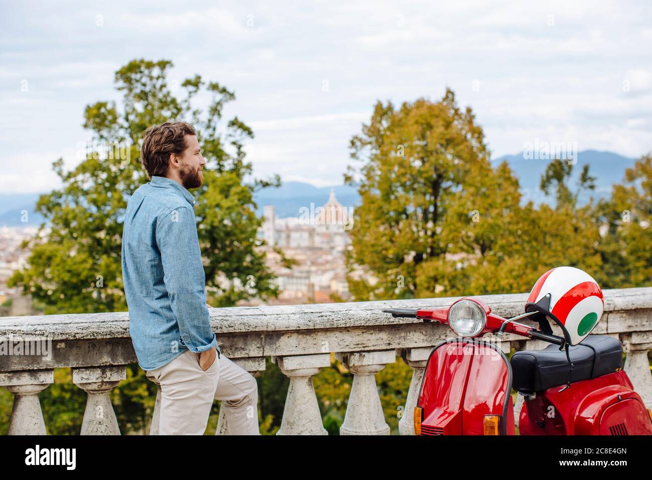 Thoughtful young man standing by railing against sky Stock Photo