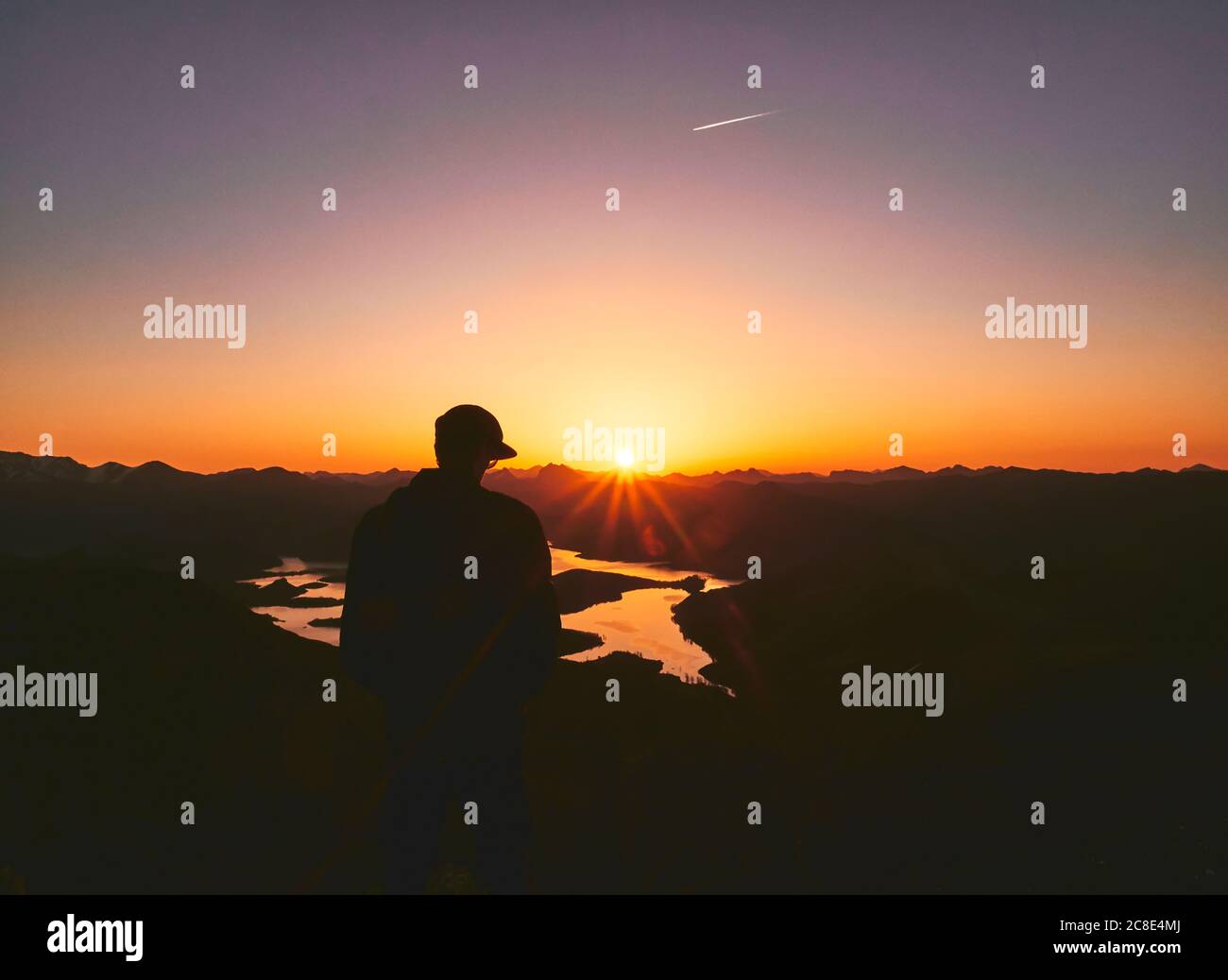 Silhouette male tourist standing on mountain during sunset, Leon, Spain Stock Photo