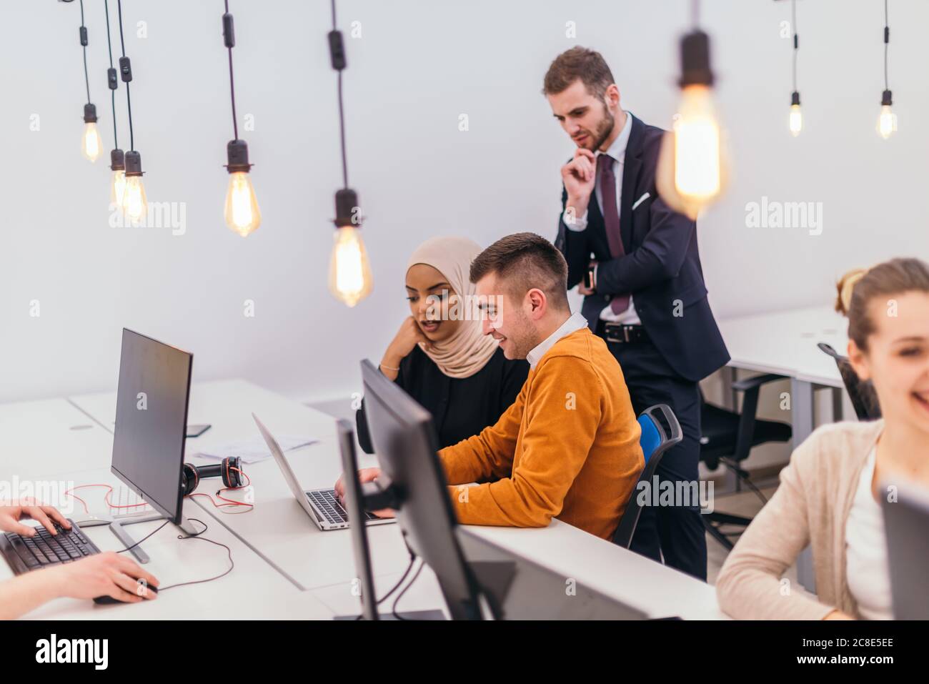 Group of multi-ethnic colleagues working on desktop computers and ...