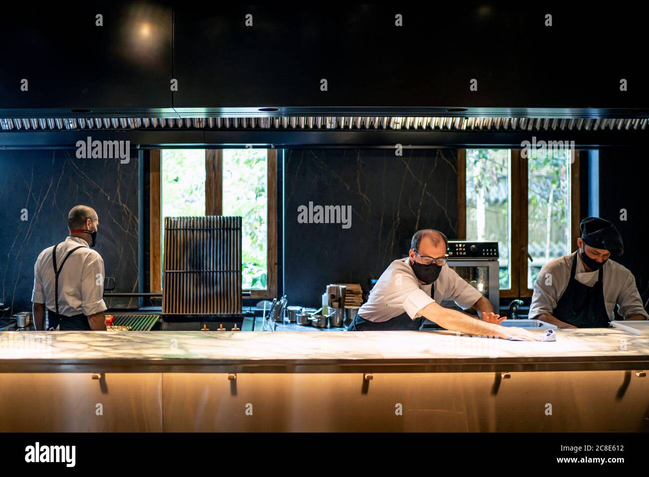 Chefs wearing protective face masks working together in restaurant kitchen Stock Photo Alamy