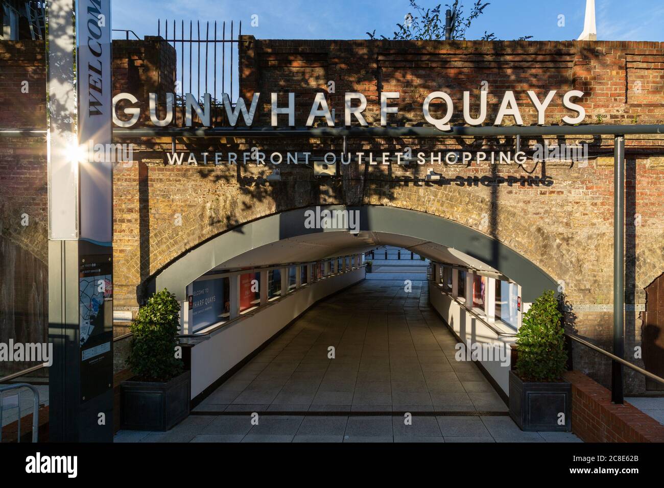 The entrance tunnel to Gunwharf Quays with sign above at sunrise Stock Photo