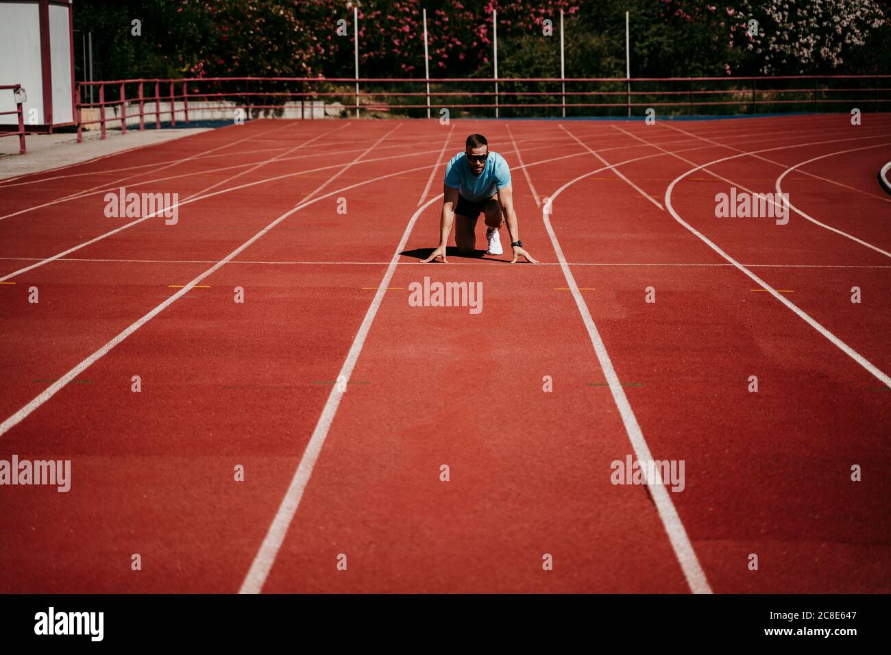 Man at running track in starting position hi-res stock photography