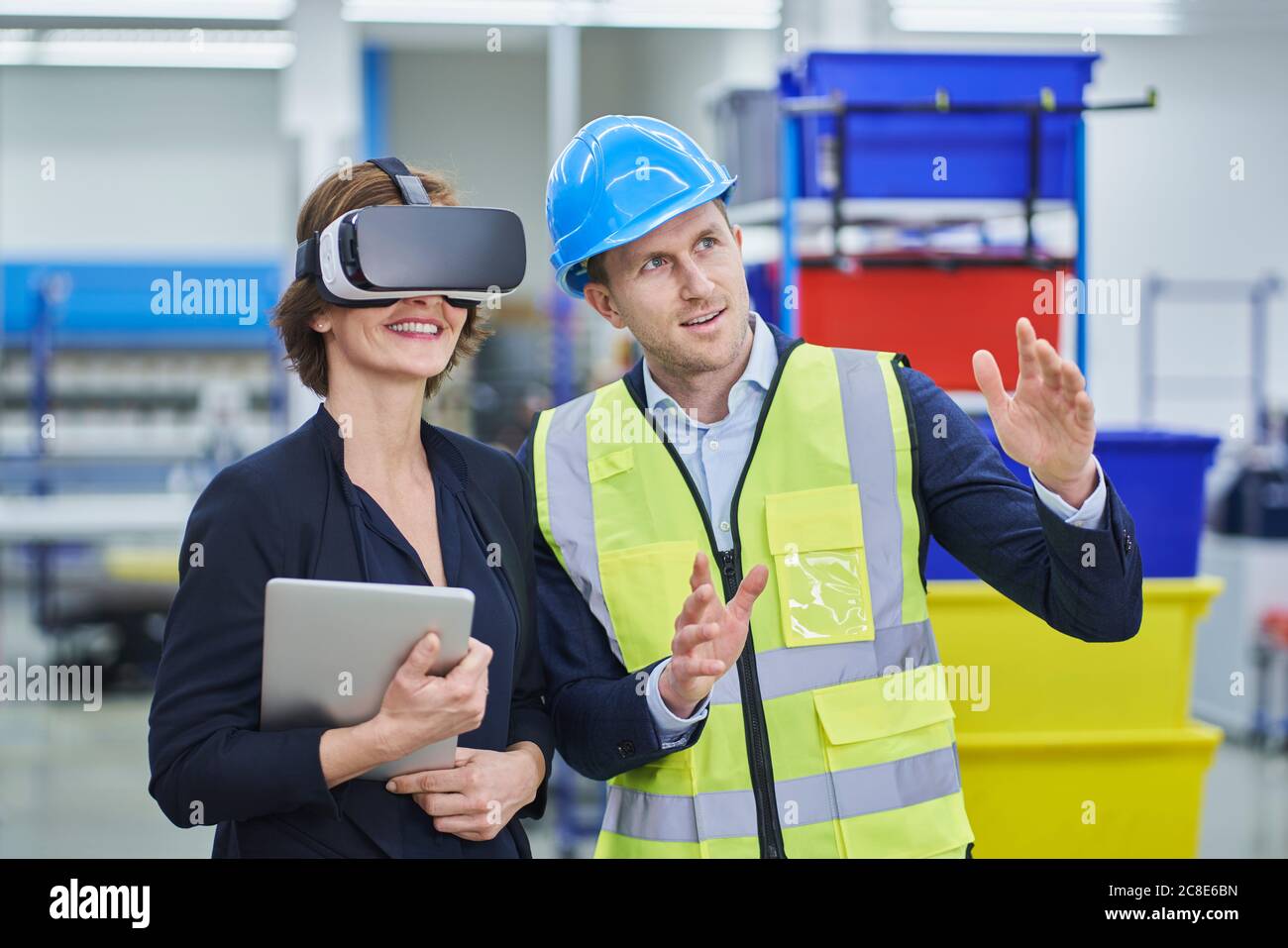 Supervisor explaining plan to female manager wearing VR glasses while ...