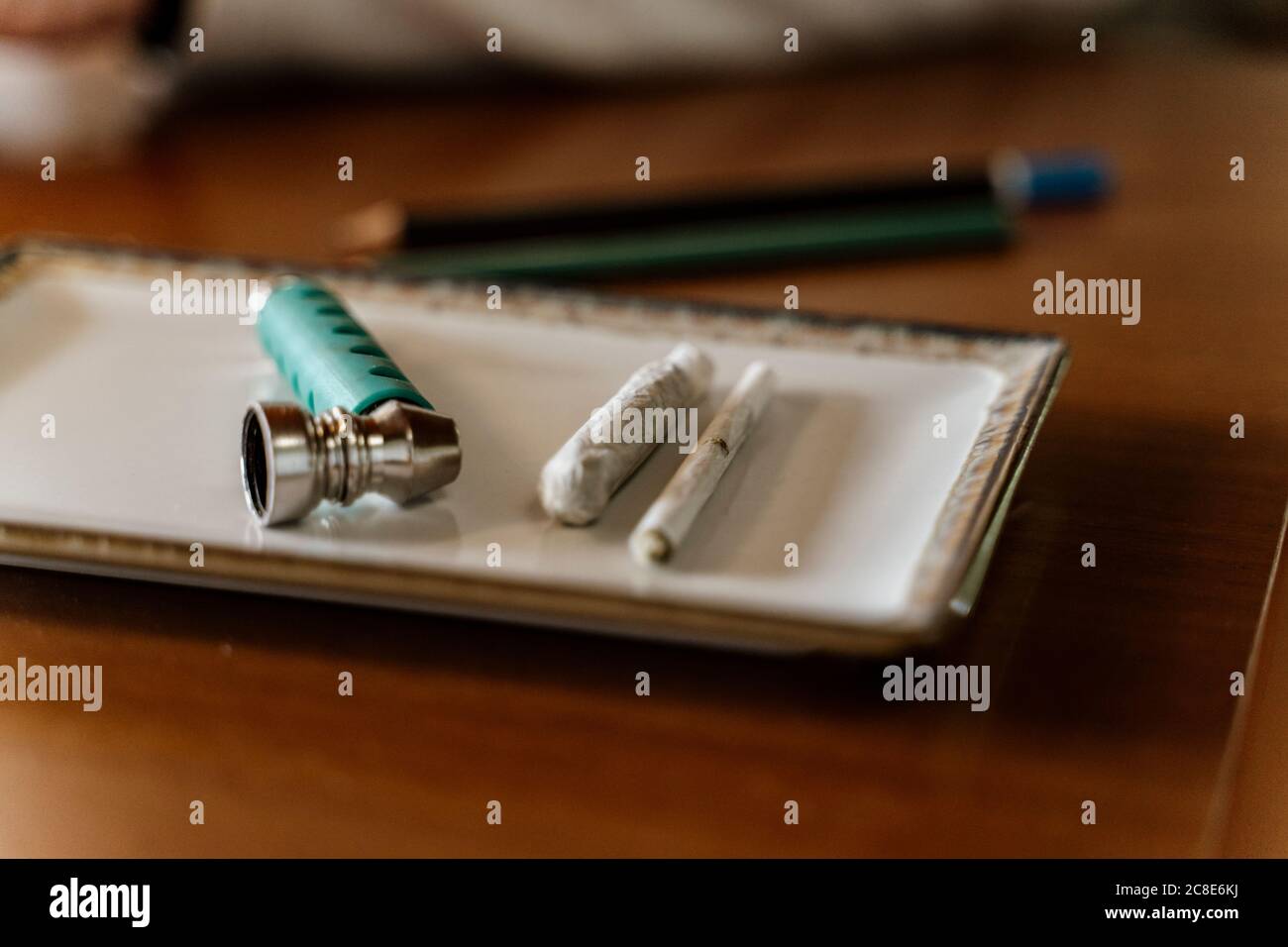 Close-up of marijuana joints and pipe in tray on table Stock Photo