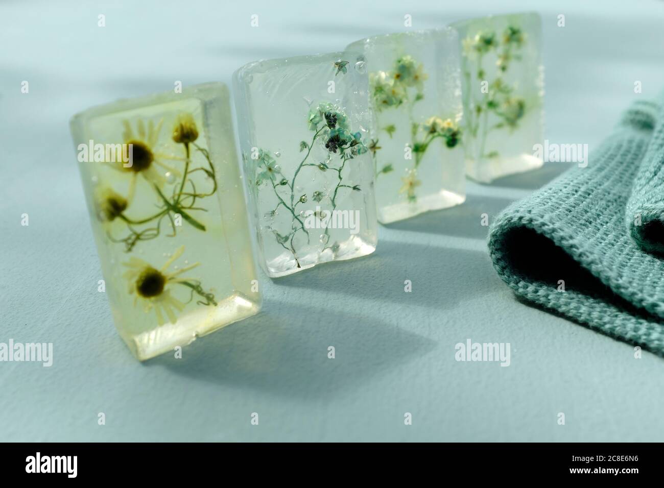Various wildflowers cast in transparent bars of glycerine soaps Stock Photo