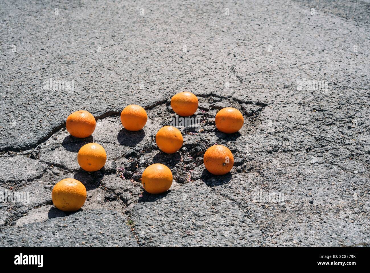 Group of oranges lying in asphalt cracks # Stock Photo