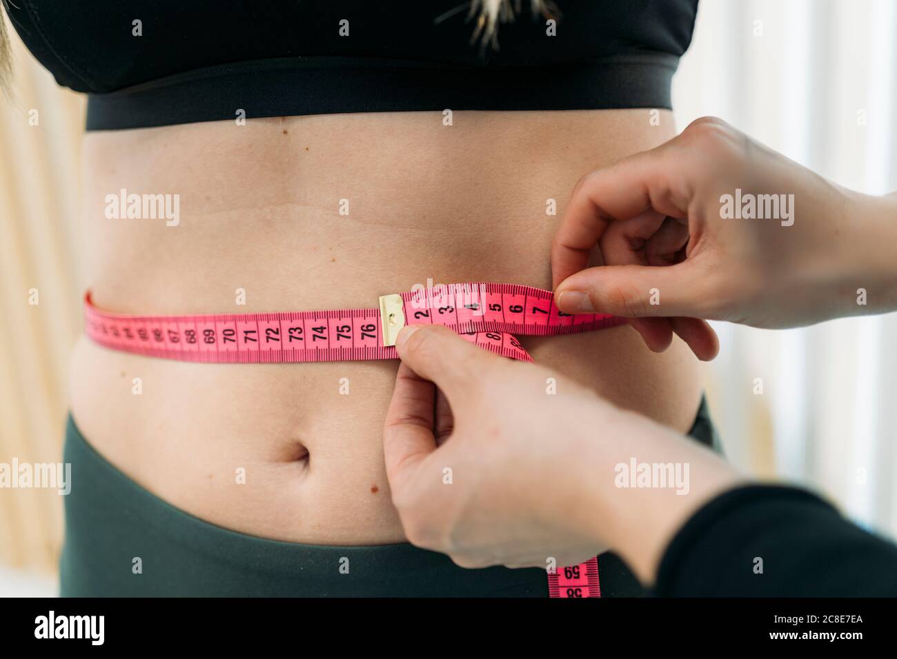 Woman measuring her waist size with a tape measure - StockFreedom - Premium  Stock Photography