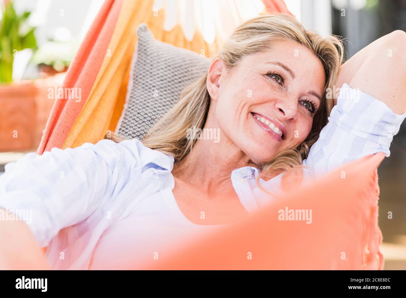 Portrait of happy mature woman relaxing in hammock Stock Photo - Alamy