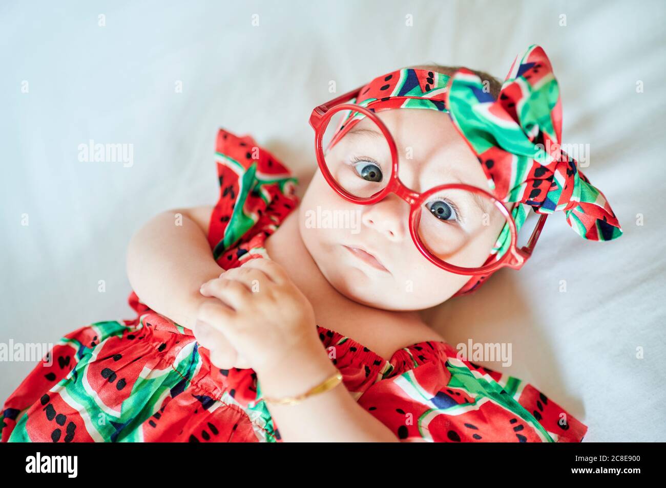 Portrait of baby girl in summer dress with oversized glasses Stock Photo