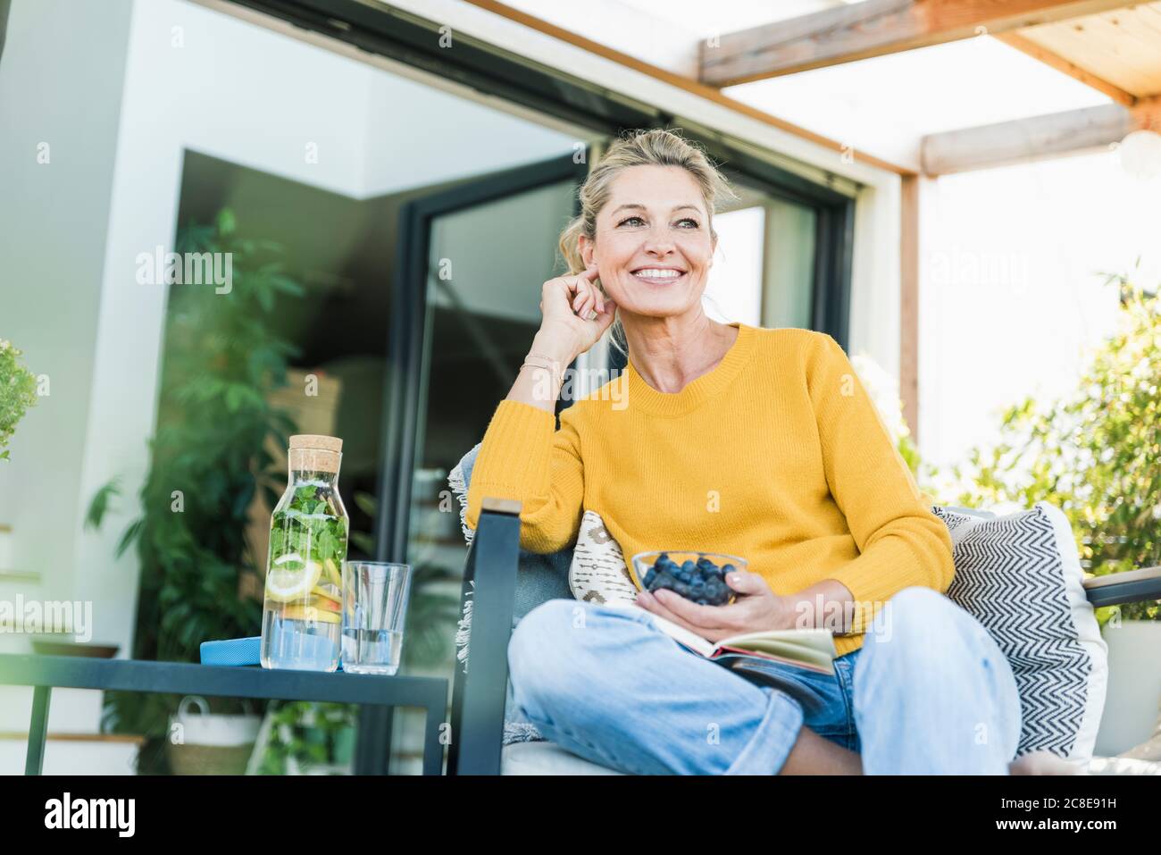 Portrait of happy mature woman relaxing on terrace Stock Photo - Alamy