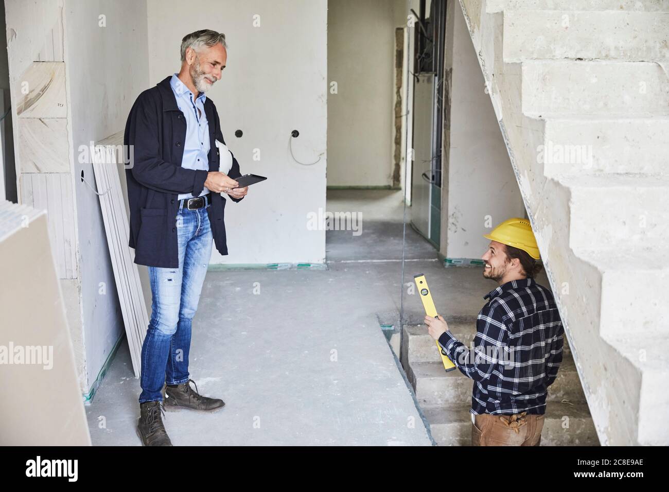 Smiling architect and worker on a construction site Stock Photo