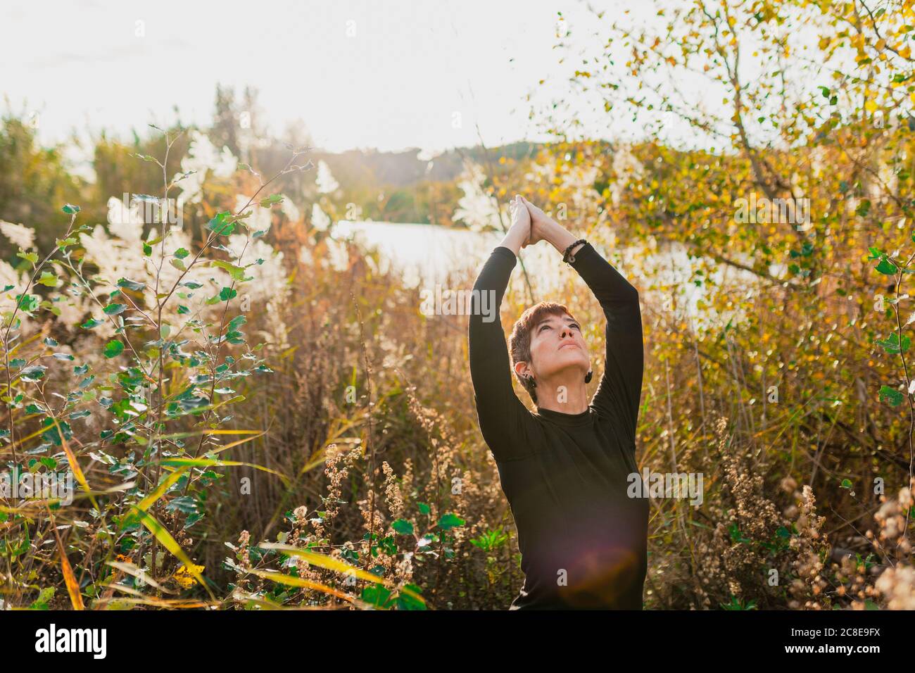 Woman stretching arms up standing hi-res stock photography and images ...