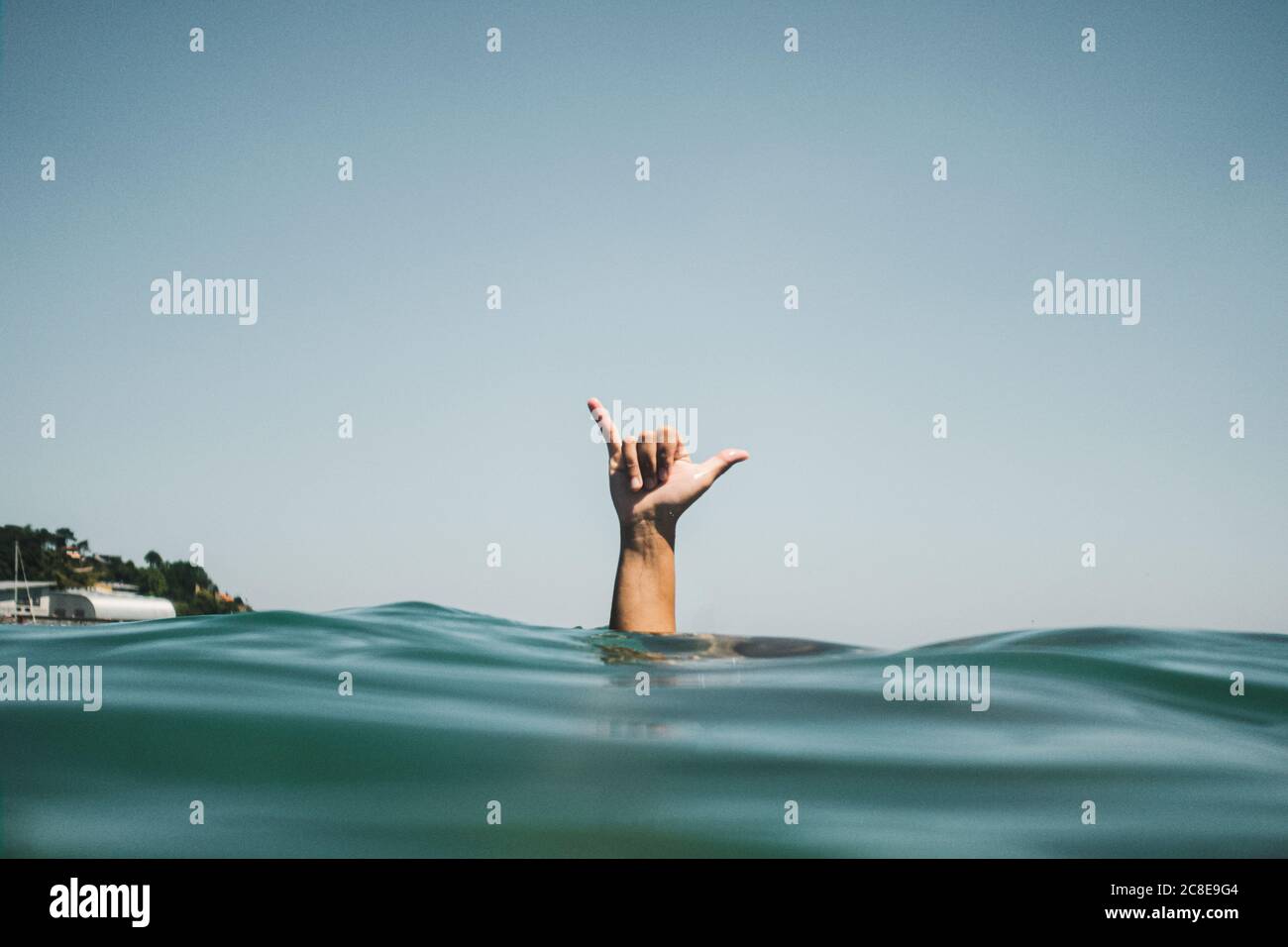 Womans hand making surfer's sign in water Stock Photo