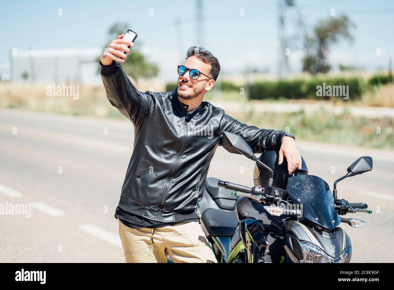 Biker with motorbike taking a selfie Stock Photo