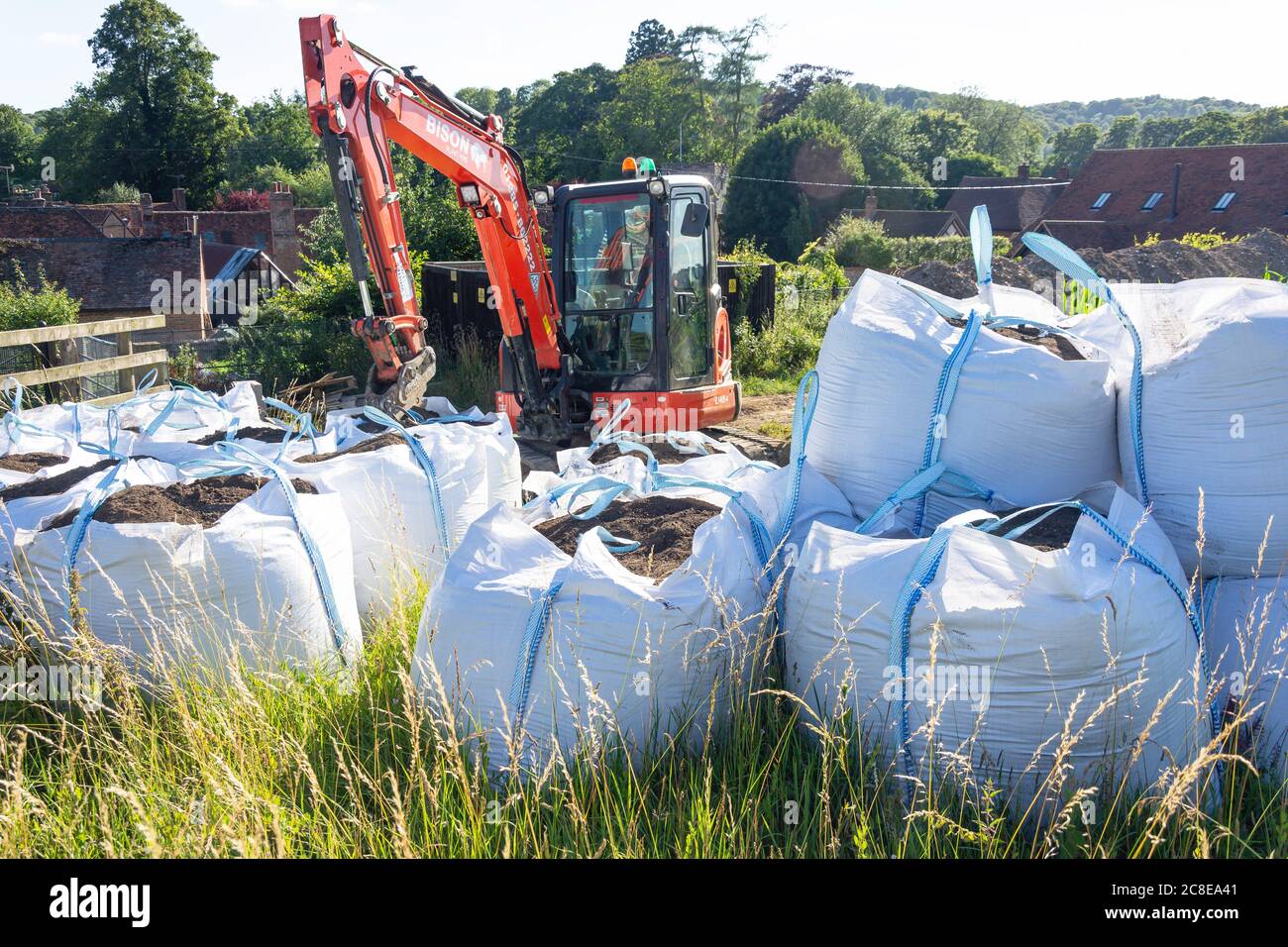 Tracked excavator and bags of earth in field, Turville, Buckinghamshire, England, United Kingdom Stock Photo
