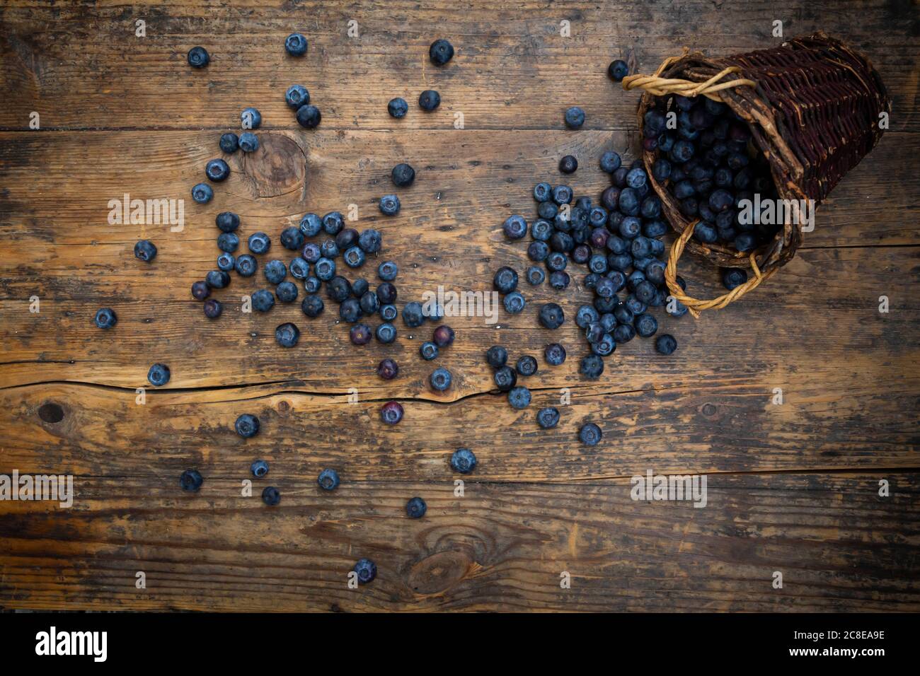 Fresh blueberries spilling from wicker basket Stock Photo