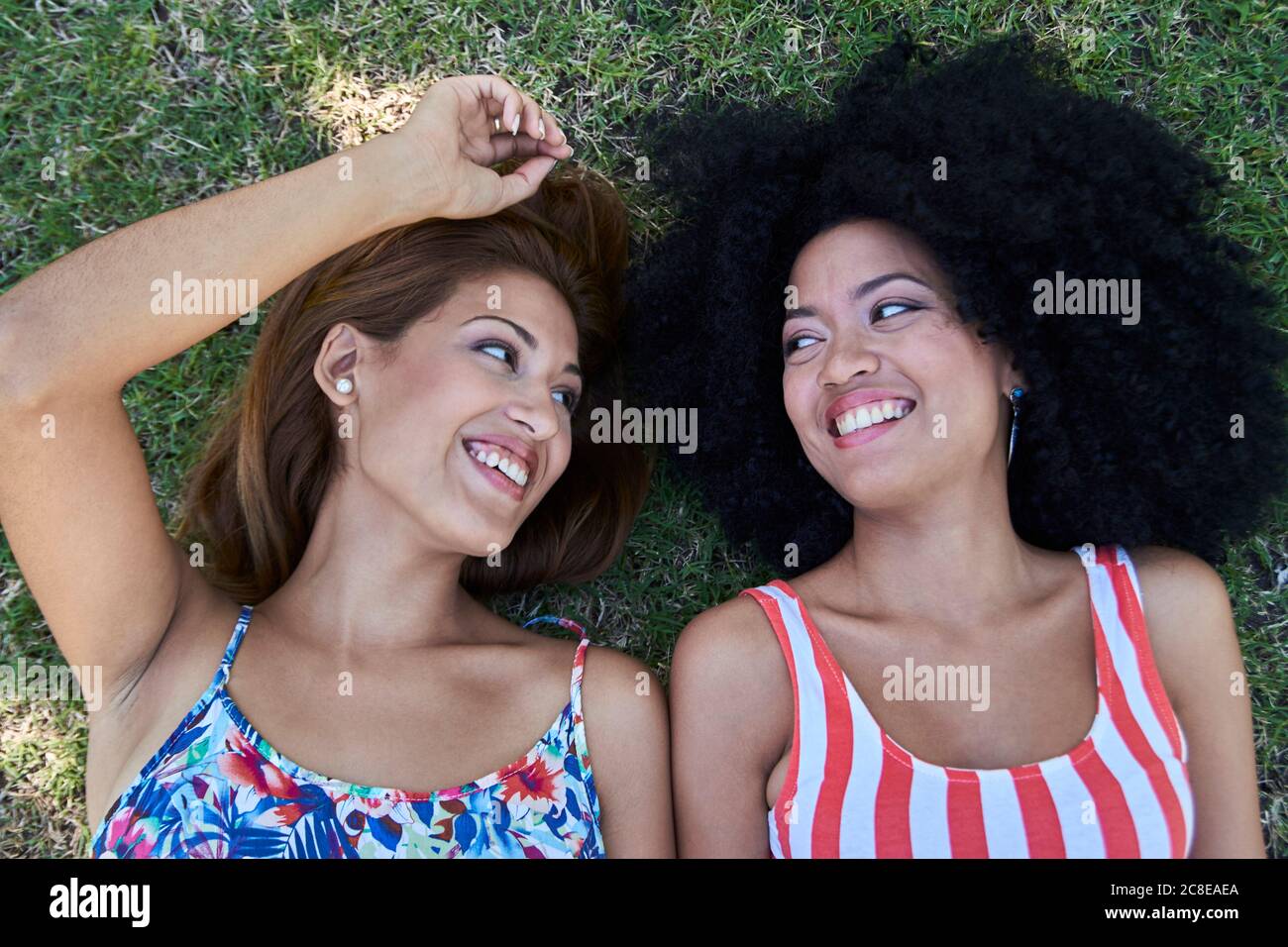 Girlfriends lying on meadow Stock Photo