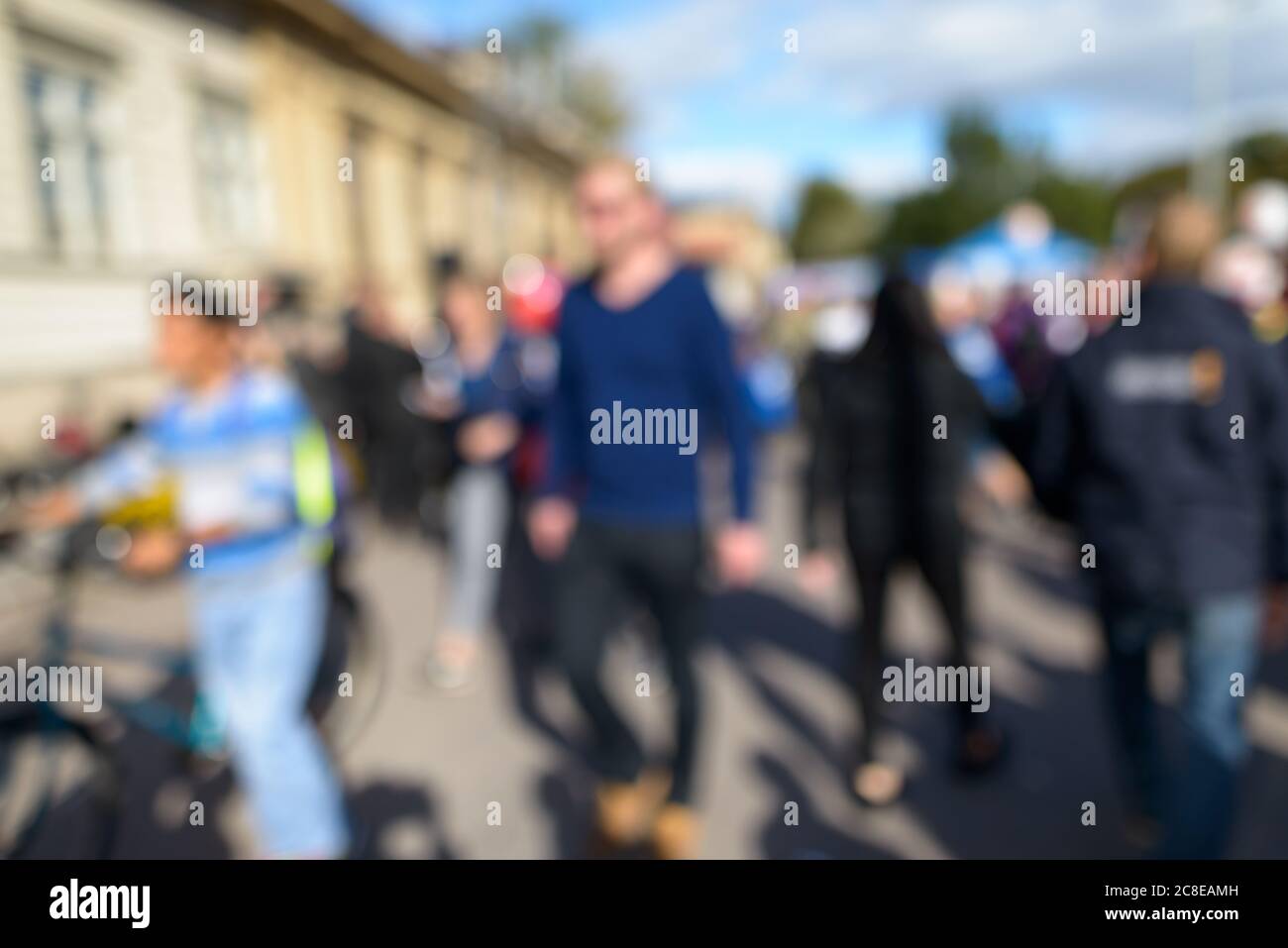 Defocused crowd of people looking busy in the city street on sunny day Stock Photo