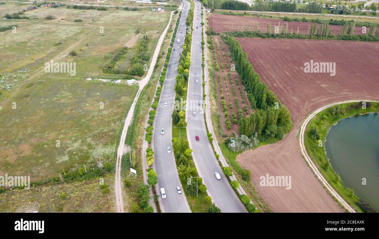 Aerial view of the double lane road near the agriculture fields. Stock Photo